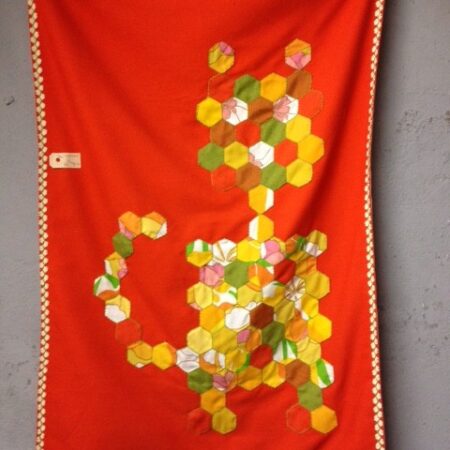 Retro quilted wandkleed poes in oranje en groen uit de jaren 1950