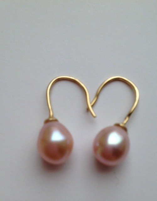 Oorbellen met glanzende rose parel aan gouden oorhangers