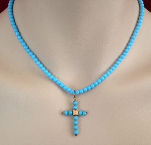 Antiek kruisje in goud en turkoois aan collier van turkoois kleurige glaskralen rond 1900