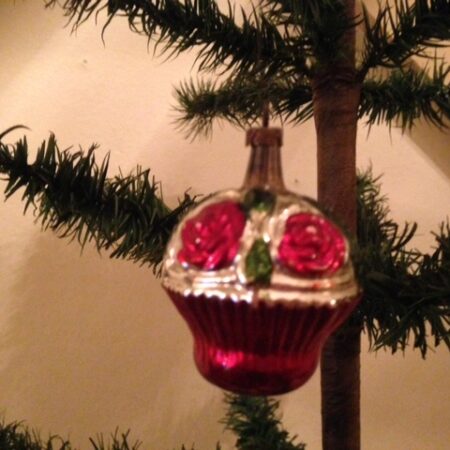 Antieke kerstbal een bloemenmand met rozen in groen en rood