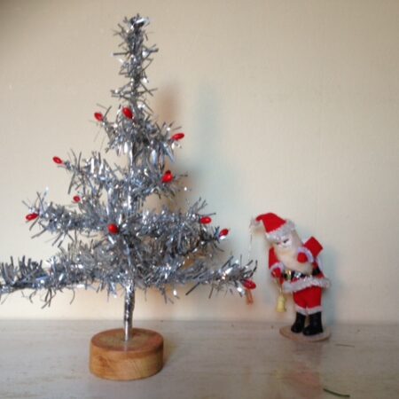 Antieke, oude tinsel kerstboom met rode besjes van was op houten blokje 1950