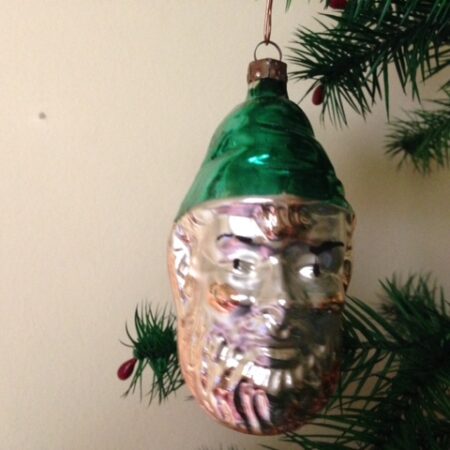 Antieke oude kerstbal van dun geblazen glas het grote hoofd van Koning Winter met groene muts