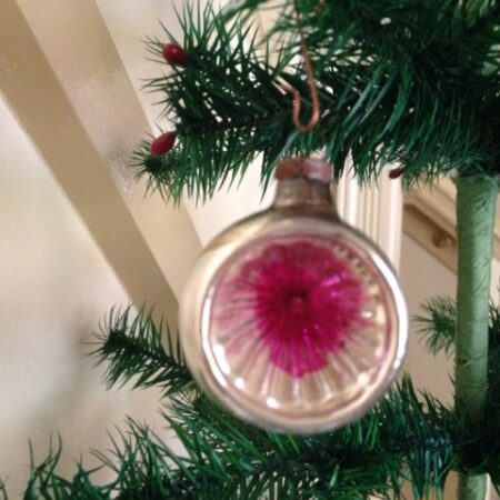 Kleine antieke reflex of deukbal in zilver met fel roze