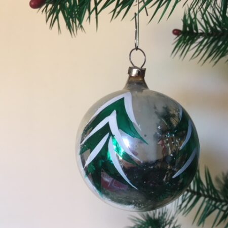 Oude antieke kerstbal in zilver met beschilderde dennenbomen midden 1900