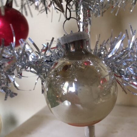 Piepkleine kerstbal van glas in zilver met prachtige patine voor feathertree of tinselboompje