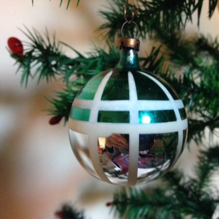 Oude antieke retro kerstbal van dun glas in zilver met groen, witte ruit uit de fifty's