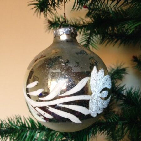 Oude kerstbal van glas uit de seventies met florale decoratie van witte verf