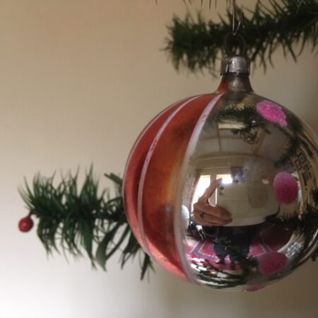 Oude retro kerstbal van dun geblazen glas in zilver, rood en wit