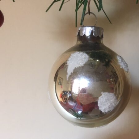 Oude kerstbal van geblazen glas in zilver met witte sneeuwvlokken midden