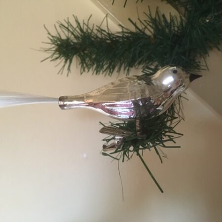 Oude kerstvogel van dun geblazen glas in zilver met zwarte snavel en volle staart midden vorige eeuw