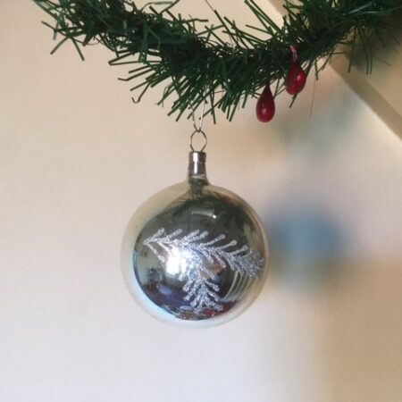 Oude antieke ronde kerstbal van dun geblazen glas in zilver met zilveren kersttak midden 1900