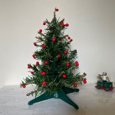 Oude retro, groene mini kerstboom vol met rode besjes jaren 1960