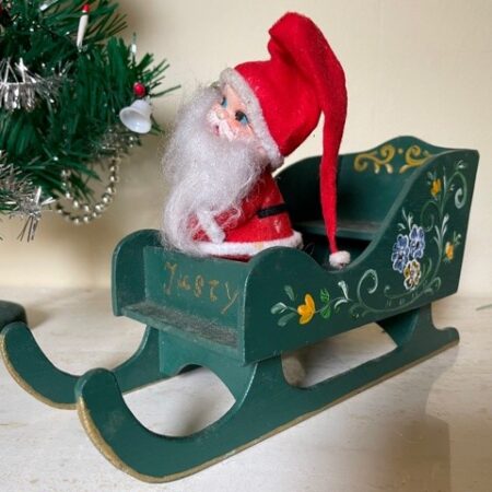 Oude, vintage slee waarin een vrolijke fifty's kerstman