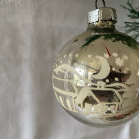 Oude antieke kerstbal van dun geblazen glas in zilver met Kerst dorp in de sneeuw midden 1900