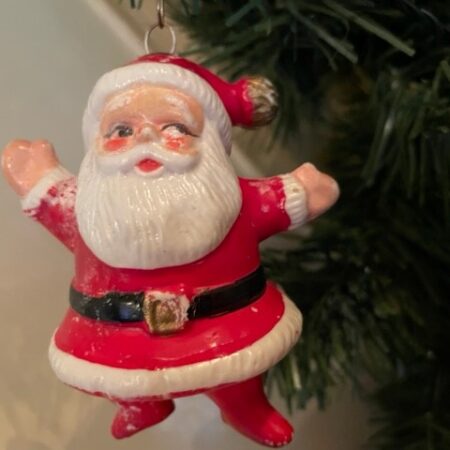 Oude, vrolijke retro kerstman van dun plastic in rood, zwart en goud 1940-1950