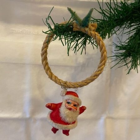 Retro kerstman van plastic, stof en chenille zwaaiend aan touwring midden 1900