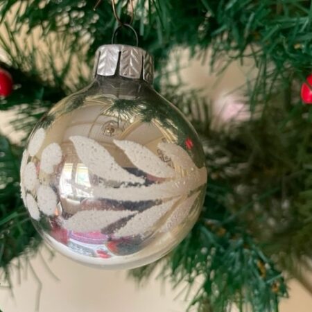 Oude kerstbal van geblazen glas in zilver met witte florale decoratie midden 1900