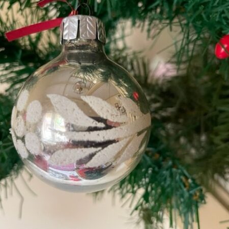 Oude kerstbal van geblazen glas in zilver met witte florale decoratie midden 1900