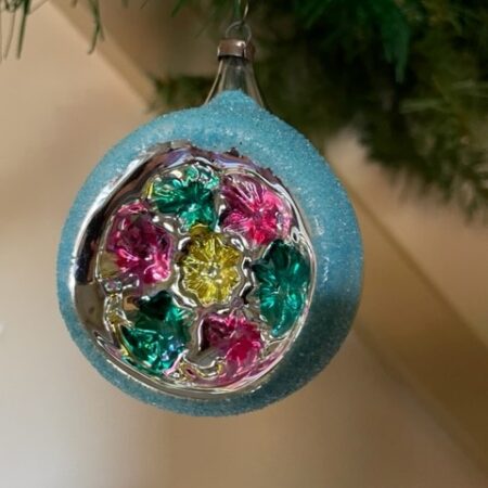 Oude antieke kerstbal van dun geblazen glas met reflex of deuk waarin bloemen in relief midden 1900
