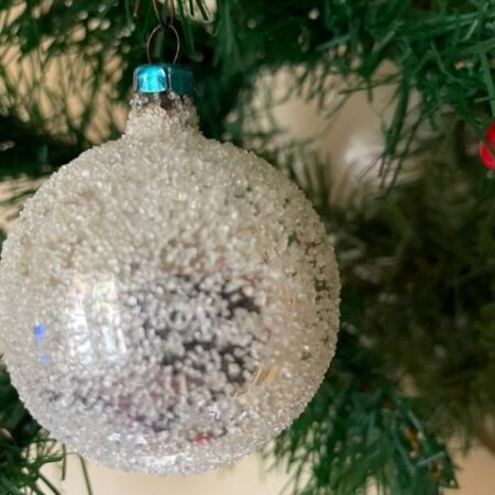 Oude ronde kerstbal van dun geblazen glas in zilver en bestrooid met glasparels 1950-1970