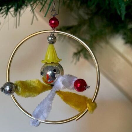 Gablonz acrobaat van glas, plastic en chenille in goudkleurige ring 2e kwart 1900