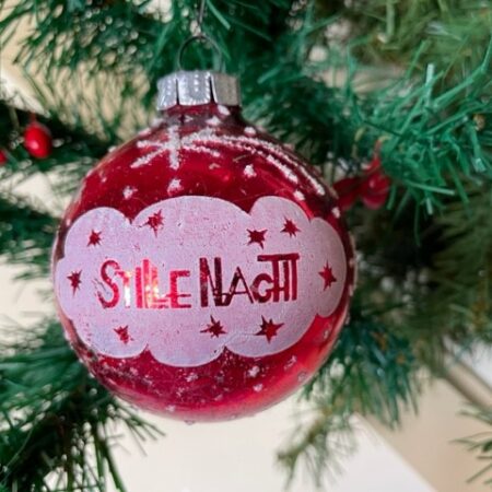 Oude antieke kerstbal van geblazen glas in rood met witte decoratie "Stille Nacht" midden 1900