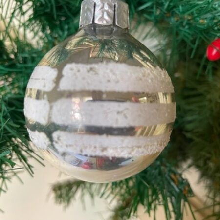 Oude kerstbal van glas en gedecoreerd met banden glasgruis en witte verf midden 1900