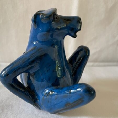 Beeldje in blauw glazuur van peinzende kont krabbende aap