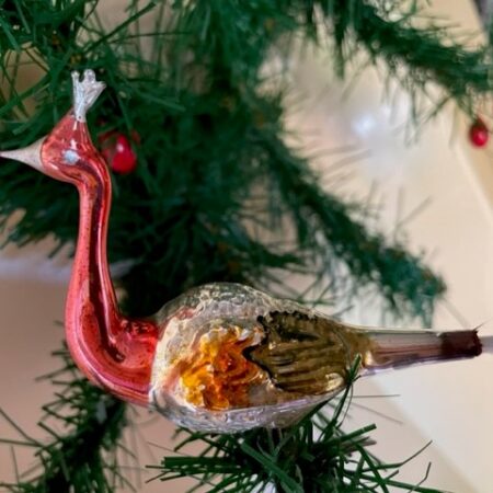 Antieke oude Kerst vogel een pauw met kroon van dun geblazen glas in roze, oranje en mosgroen op 1 poot