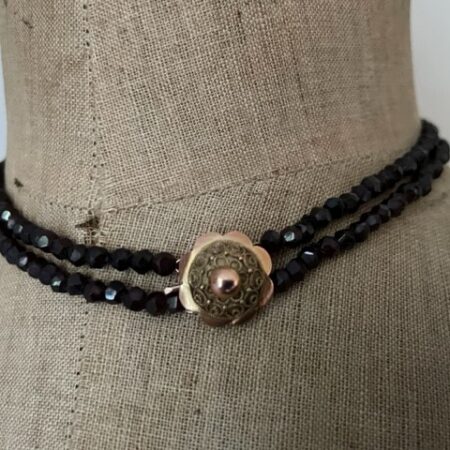 Collier 2 rijig met granaten aan 14kt. geelgouden bloemvormig rond slot met filigrain