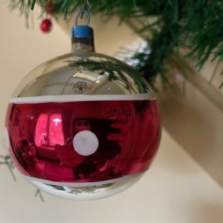 Oude retro kerstbal van dun geblazen glas in zilver, rood en witte polka dots
