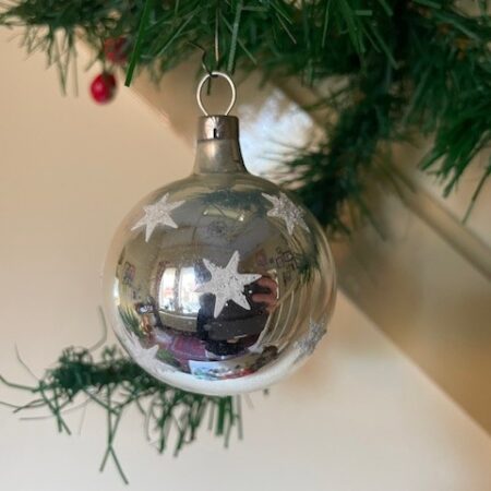 Antieke oude kerstbal van dun geblazen glas in zilver en bezaaid met kerststerren 1e helft 1900