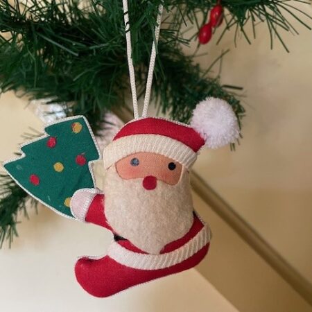 Oude retro kerstman met kerstboom van verschillende stoffen in rood, groen, wit en goud midden 1900