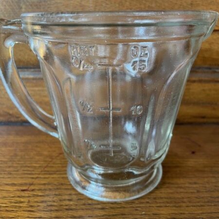 Vintage retro maatkan of maatbeker van dik helder persglas op voet met oor
