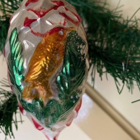 Giga grote dennenappel van dun geblazen glas geel, groen en rood met een vogel op een dennentak in relief