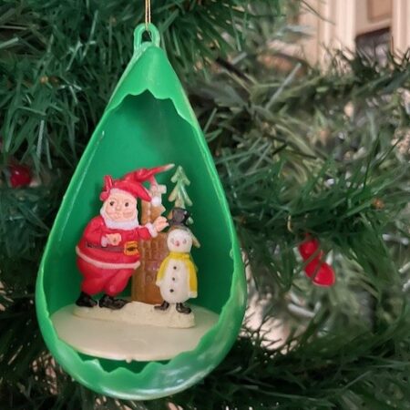 Retro diorama kerstbal van groen plastic met vrolijke voorstelling jaren 1950