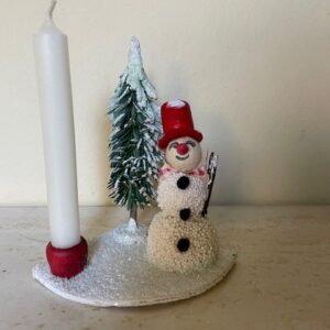 Oude antieke kaarsen standaard met een sneeuwpop en kerstboom van groen papier midden 1900