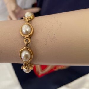 Armband goudkleurig met 8 glanzende ovale bouton faux parels