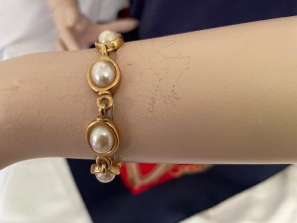 Armband goudkleurig met 8 glanzende ovale bouton faux parels